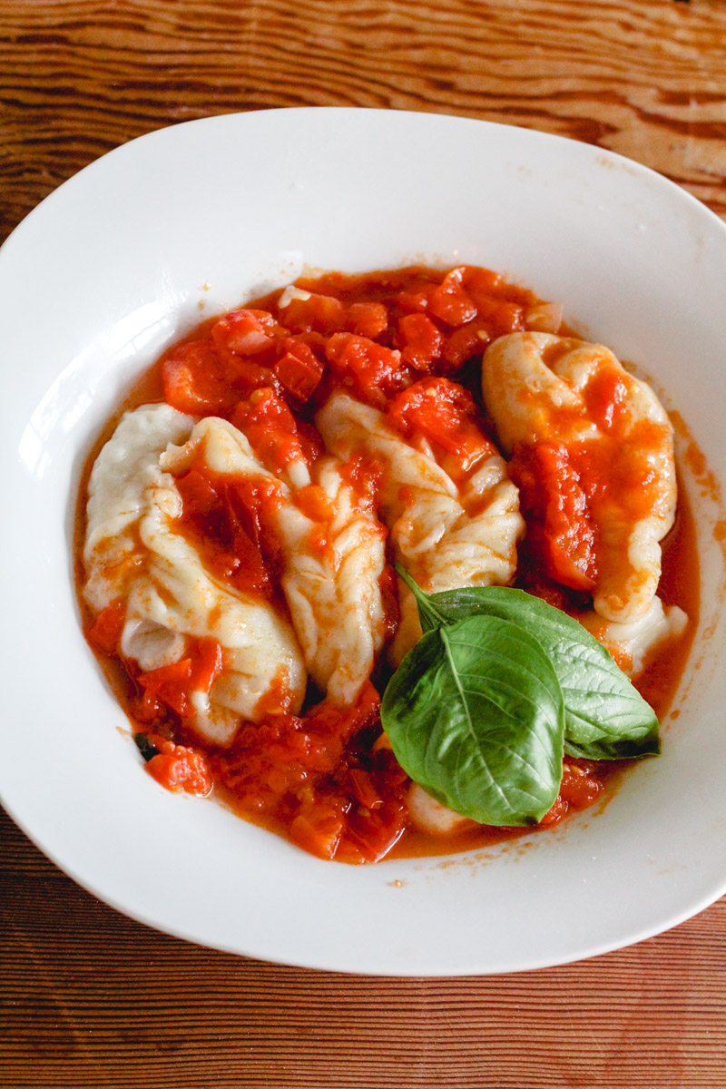overhead image of homemade Sardinian culurgiones in a white plate