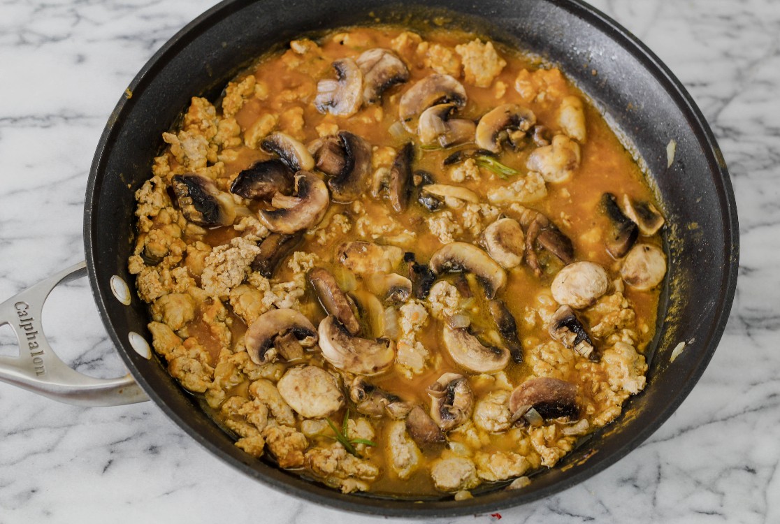 overhead image of cooking ground meat and mushrooms in a skillet.