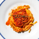 overhead image of fettuccine with weeknight lamb ragu' on a white plate