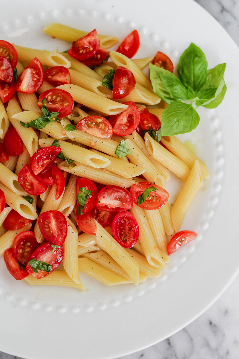 Overhead image of cherry tomato pasta on white platter.