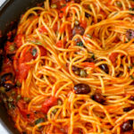 Pasta puttanesca on a skillet.