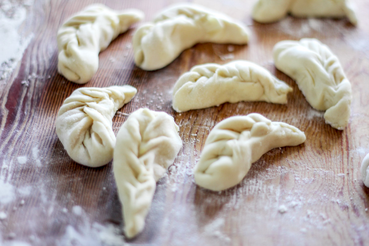 overhead image of homemade Sardinian culurgiones on a wooden board