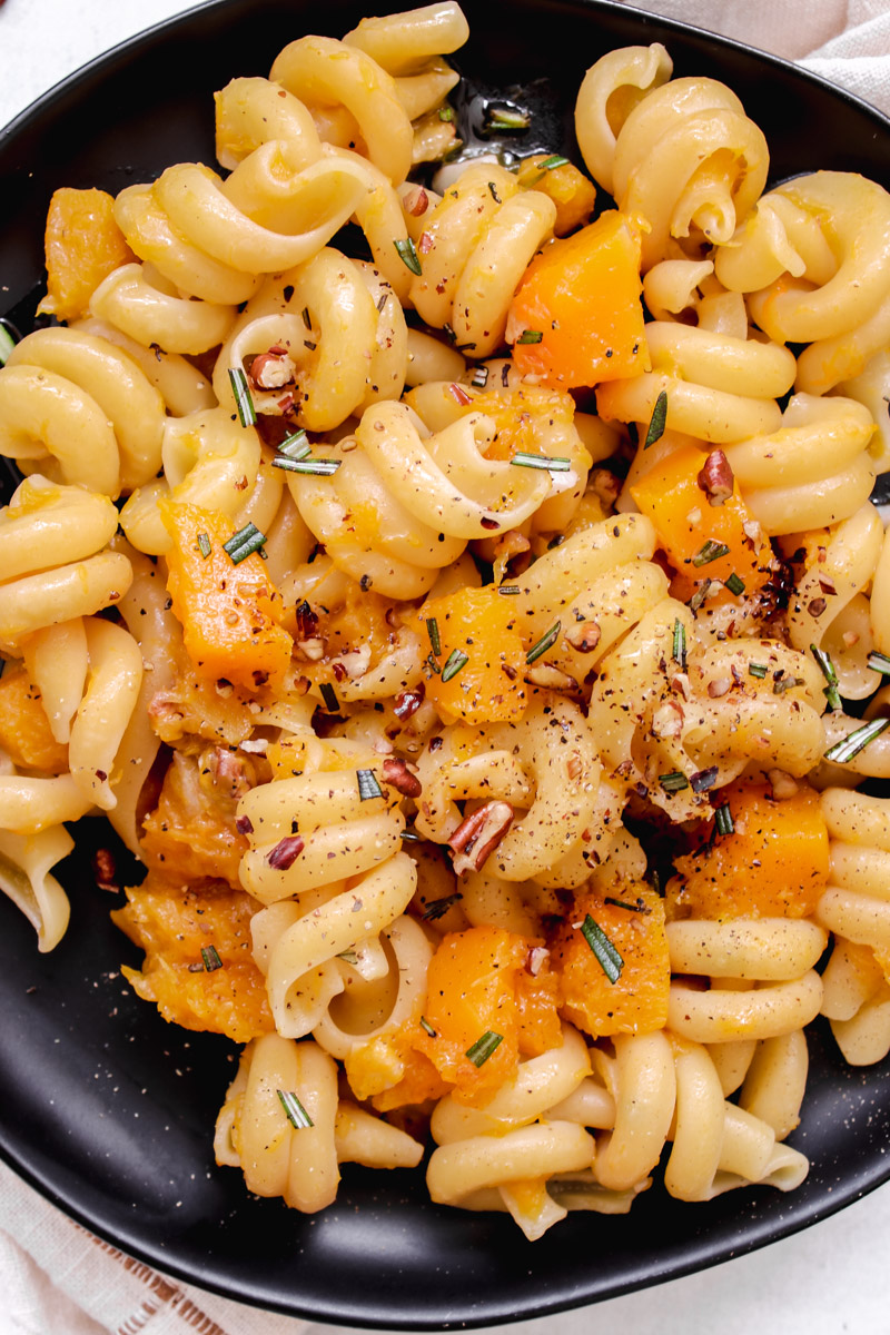 image of pasta with vegetables on a black plate