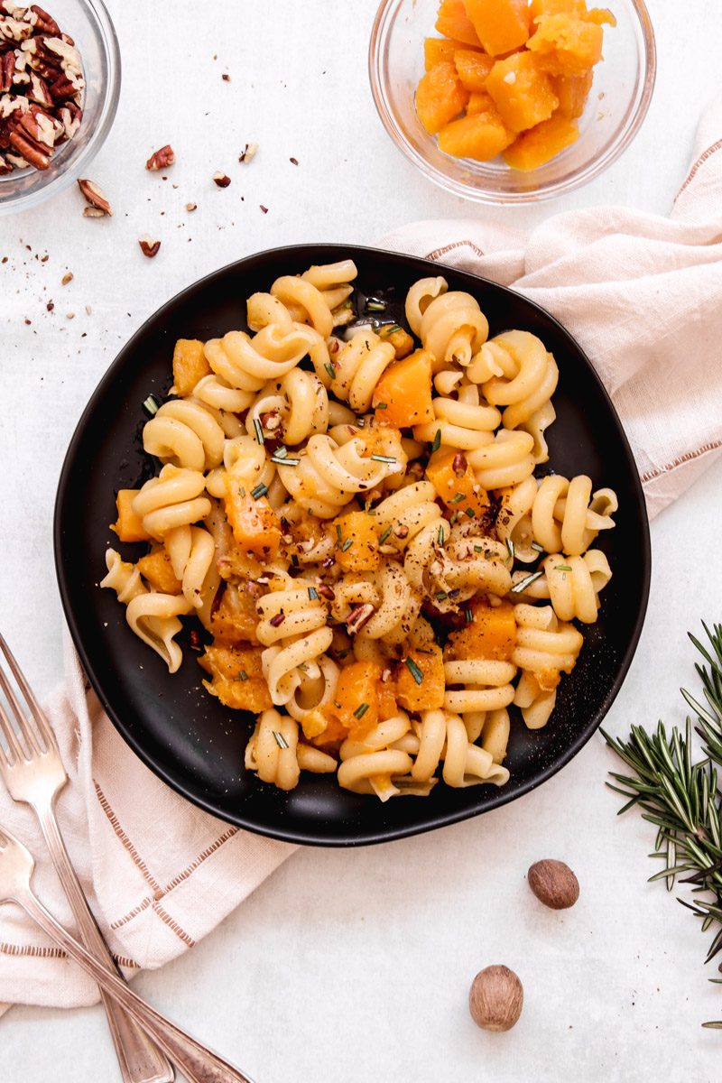 overhead image of easy vegan butternut squash pasta on a black plate