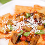 overhead image of pasta alla norma on a white plate