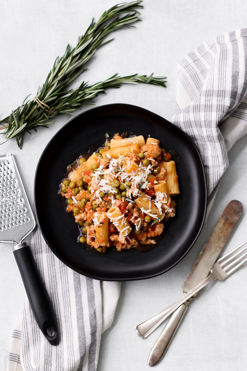 overhead image of Sicilian pasta with ground chicken on a black plate