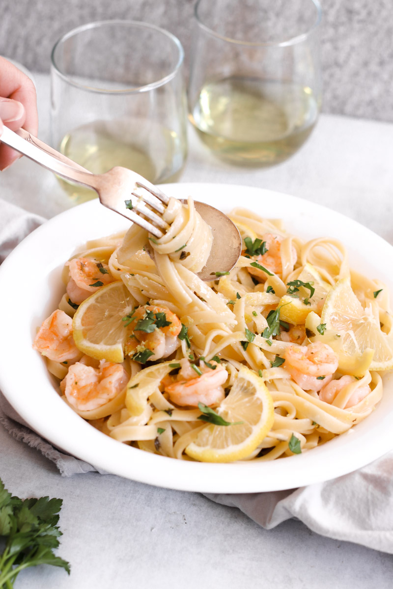 image of pasta on a fork and wine in background 