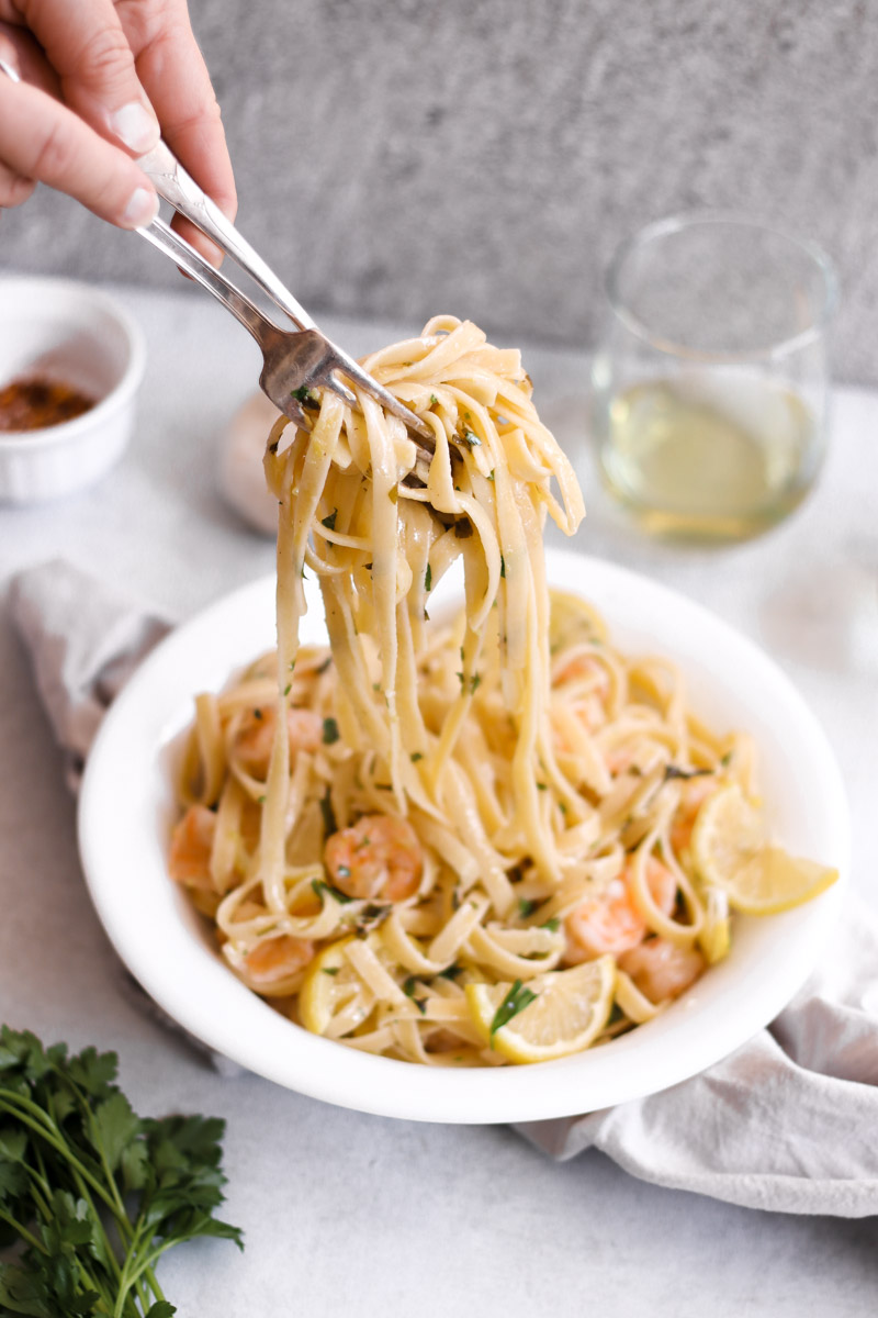 image of serving pasta with fork and a spoon in a white bowl