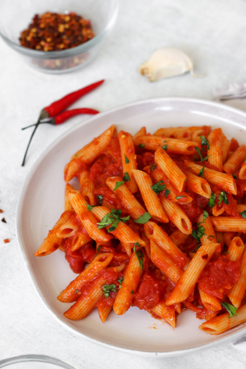 Arrabbiata pasta in white bowl with parsley.