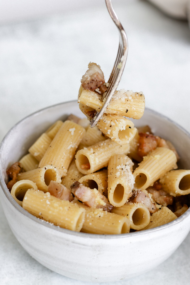 close up image of pasta on a fork in a bowl.