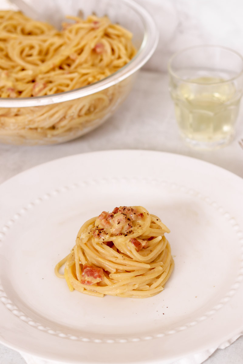 Overhead image of spaghetti carbonara on white plate.