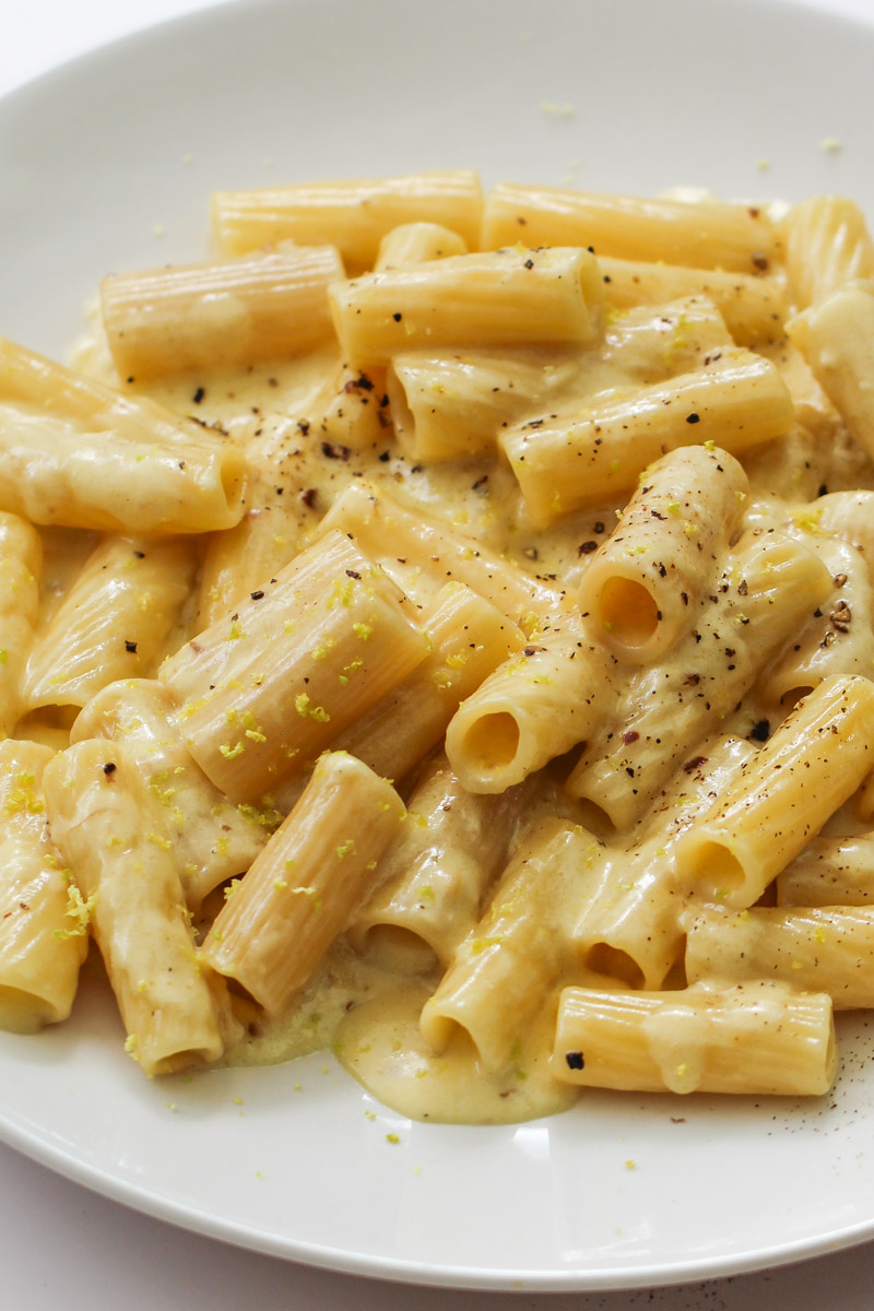 Silky garlic cream sauce coating penne pasta in a white ceramic bowl