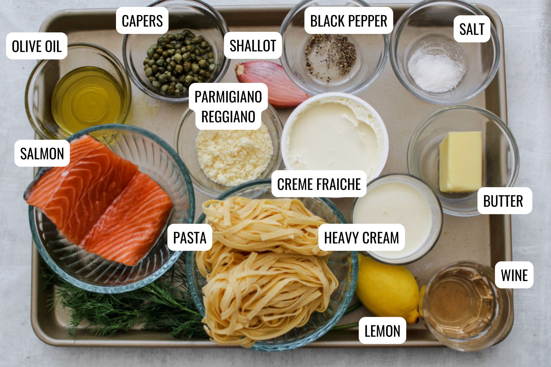 overhead image of creamy salmon pasta ingredients on a baking tray. 