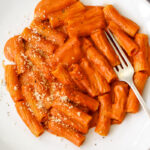 Italian creamy tomato pasta recipe plated on a white bowl with Parmesan cheese