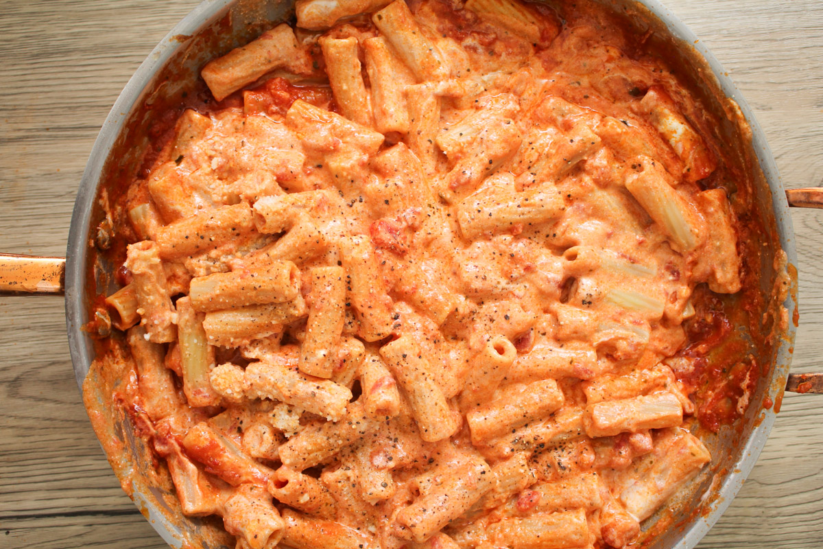 overhead image of pasta with ricotta sauce in a skillet. 