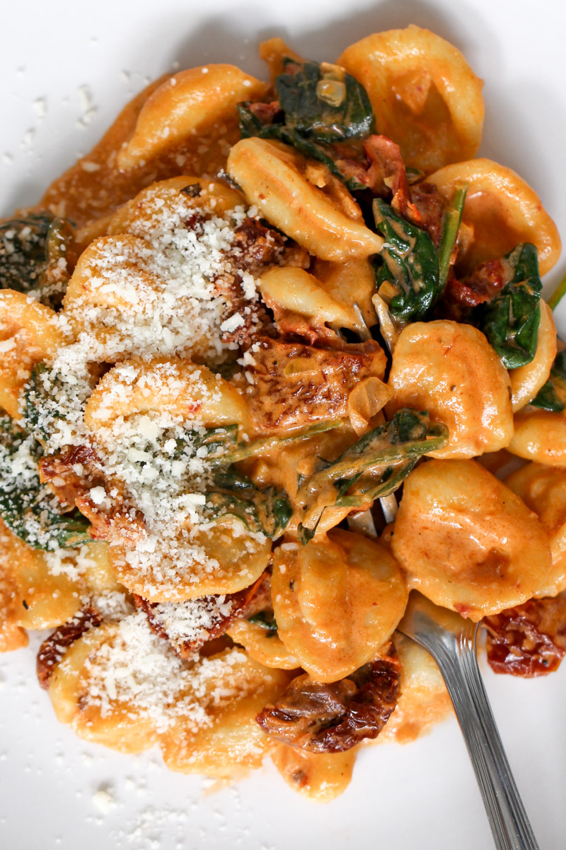 Sun dried tomato pasta on white plate.