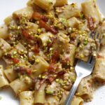 Creamy pistachio pasta on a white dish.