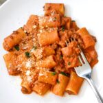 Creamy ground beef pasta on white plate.