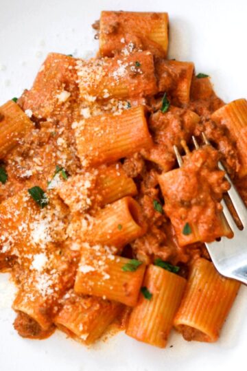Creamy ground beef pasta on white plate.