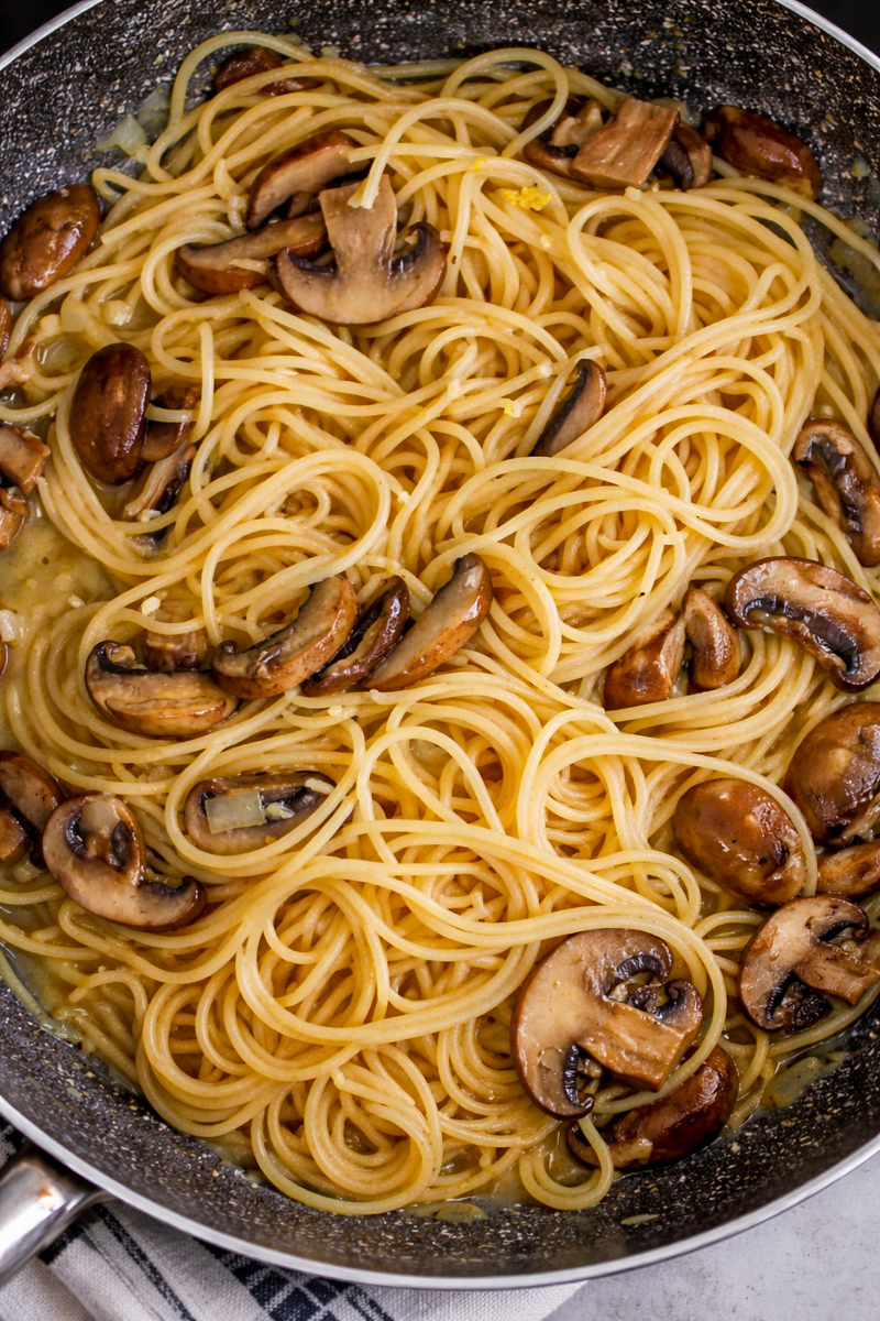Mushroom pasta with no cream and sage on white dish.